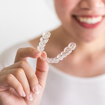 Hand holding Invisalign tray