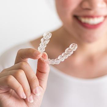 Hand holding Invisalign tray