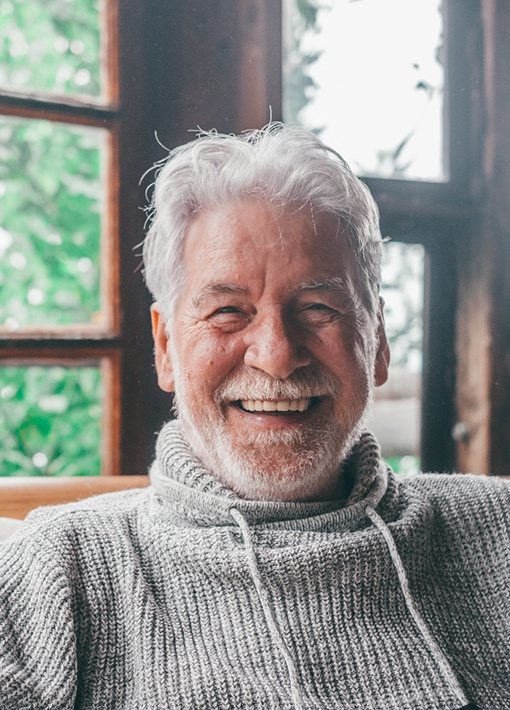 a man smiling and sitting in a chair