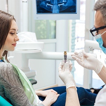 dentist showing a patient how dental implants work 