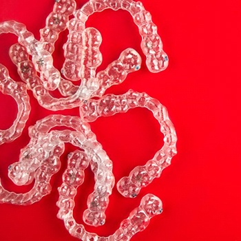 Invisalign clear aligners on red background