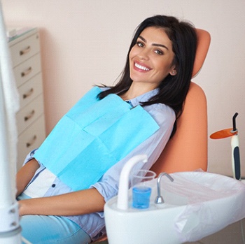 Happy, comfortable female dental patient reclining in chair