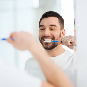 man brushing his teeth 