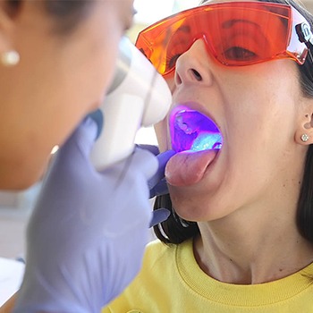 Dentist performing oral cancer screening