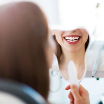 Woman looking at smile in mirror