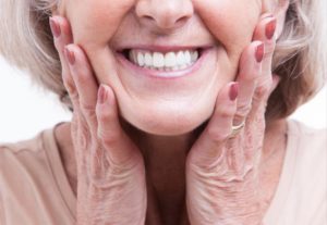 a woman happily smiling after replacing her dentures