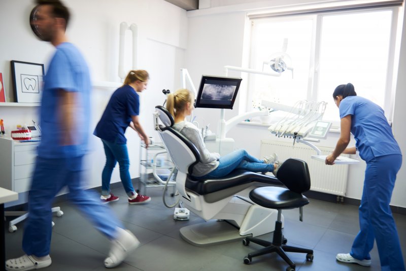Blurred dentists helping with an emergency dental visit